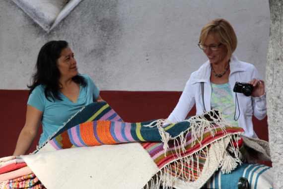 Latina women laughing and looking through rugs